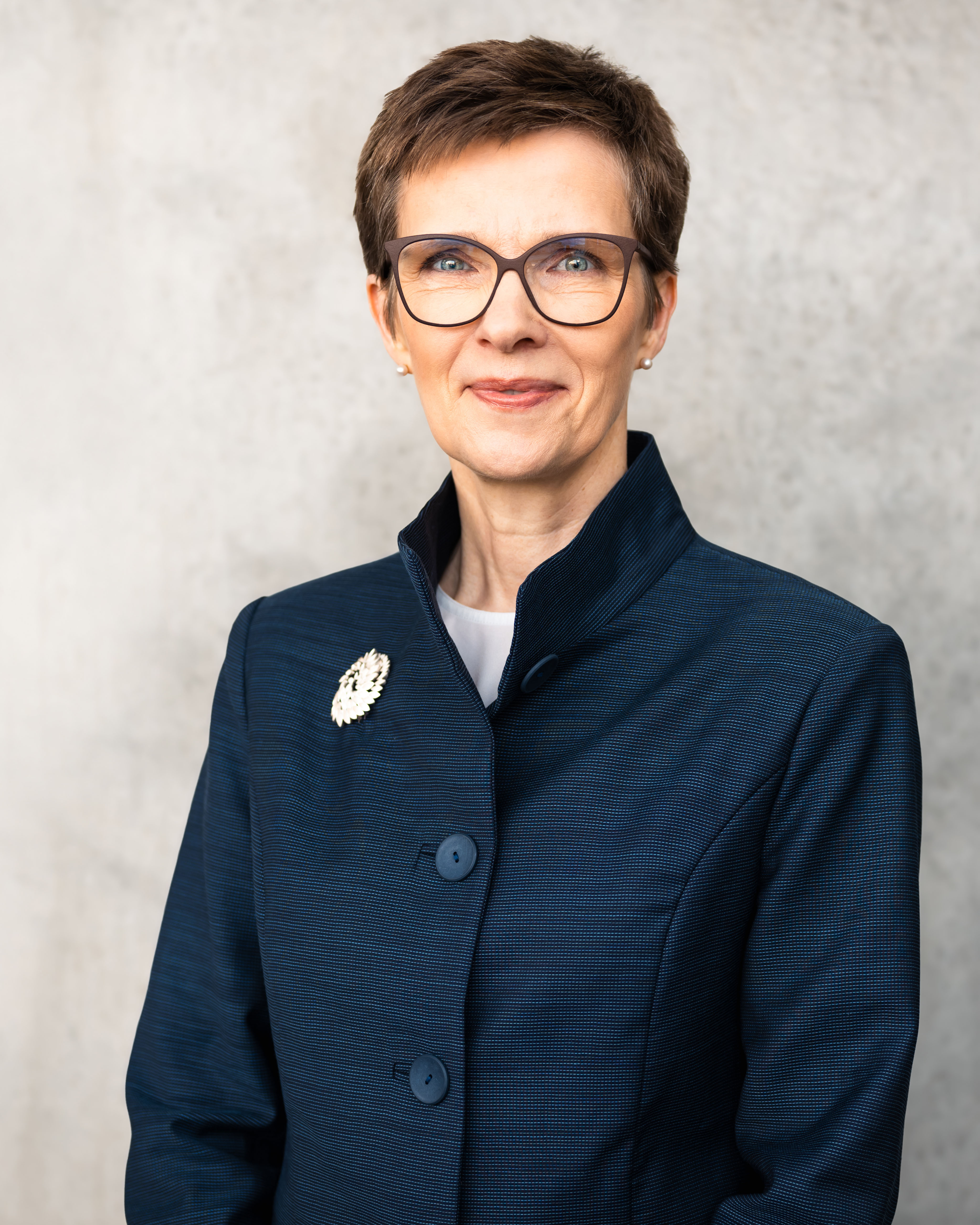 A person wearing glasses and a blue jacket

Description automatically generated